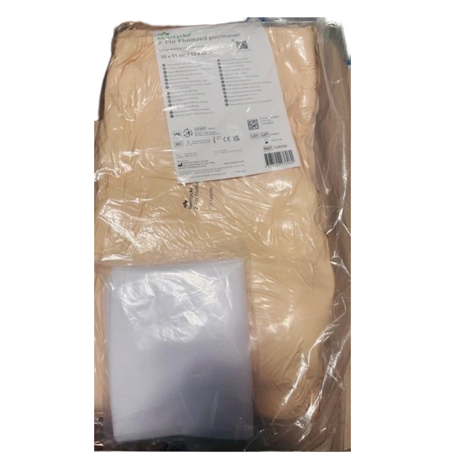 A large Mölnlycke Z-Flo Fluidized positioner, measuring 30x51cm (12x20in), showing the cream-colored pad and a white positioner cover inside a clear bag.