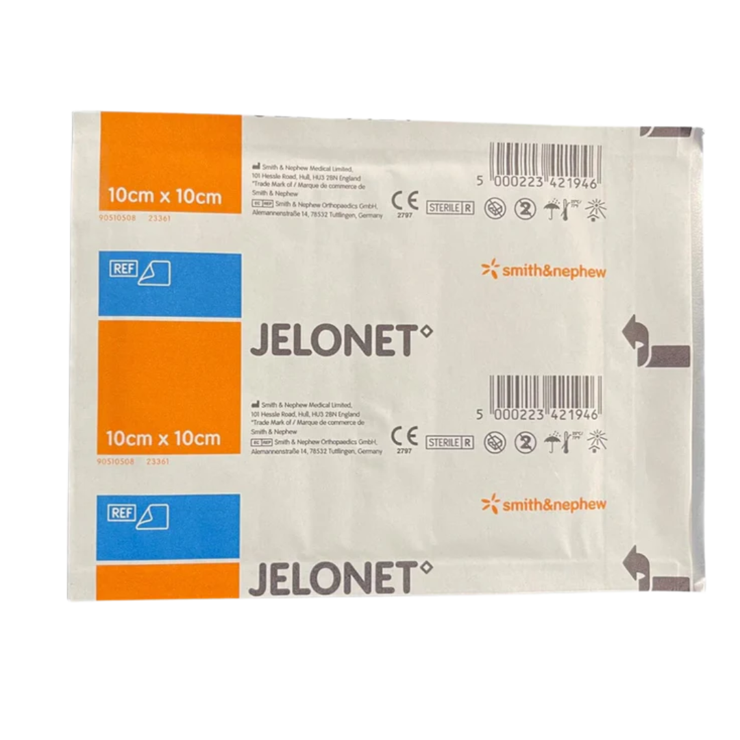 Close-up of two sterile, individually wrapped sachets of Smith & Nephew Jelonet Paraffin Gauze Dressing, size $10 \text{ cm} \times 10 \text{ cm}$.